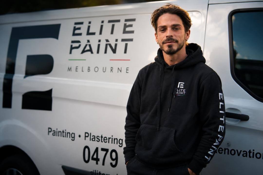 Baldo of Elite Paint Melbourne beside the branded company van