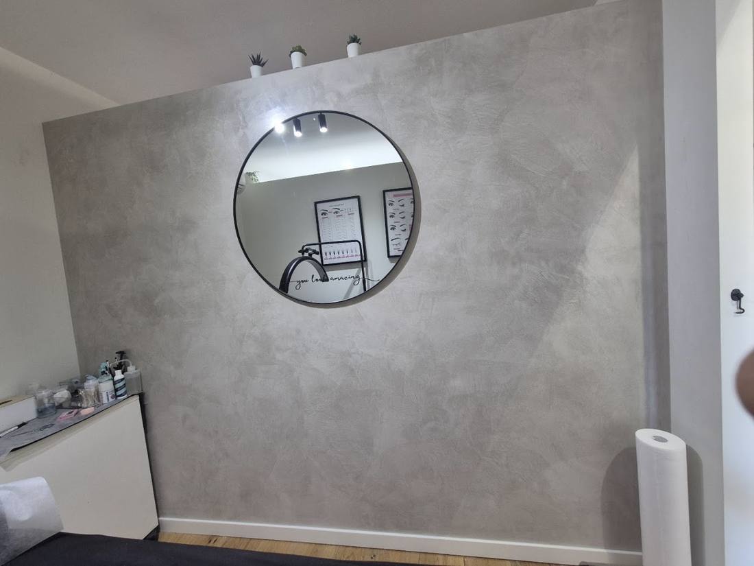 Venetian plaster feature wall with a round mirror