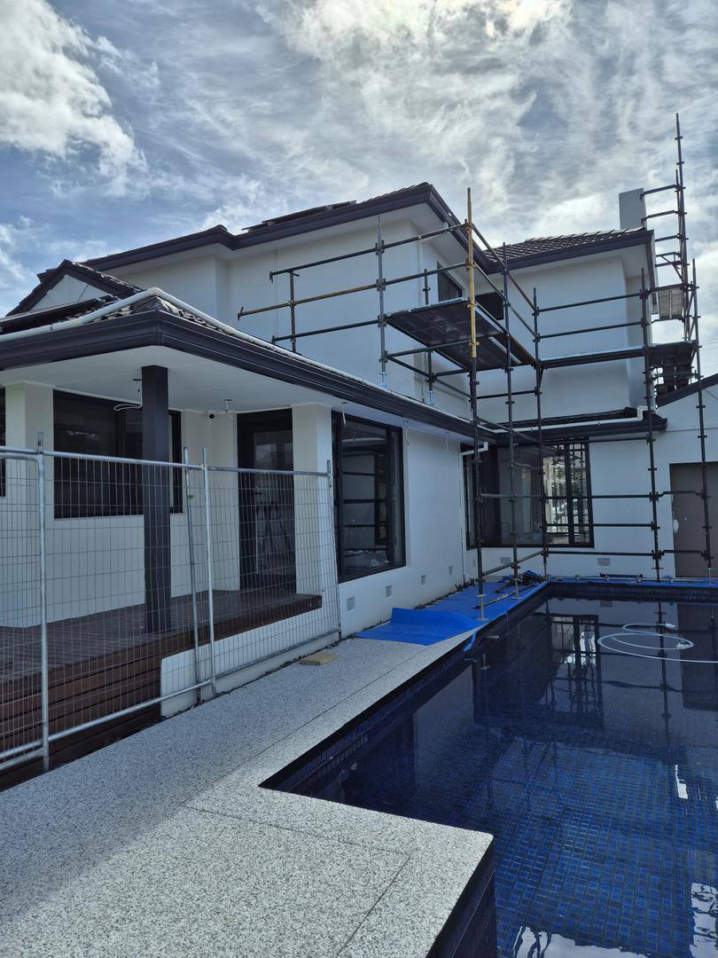 Large eastern-suburbs home exterior repainted beside a pool