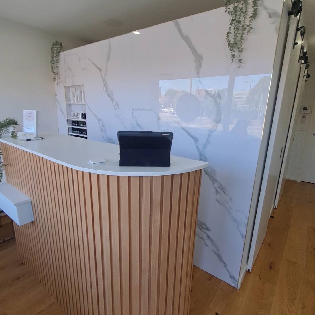 Commercial reception area with a polished plaster feature and timber batten